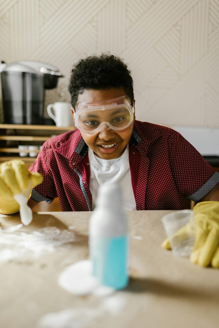 Teen engaged in hands-on chemistry experiment with safety gear at home.